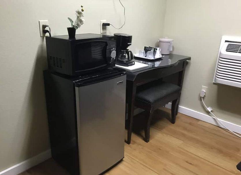 Coffee maker, microwave and mini refrigerator on a desk in a guest room