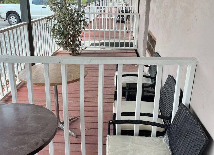 Chairs and a table on a shaded balcony