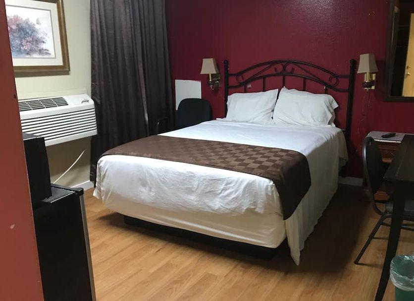 Guest bedroom with a queen bed, headboard and framed art