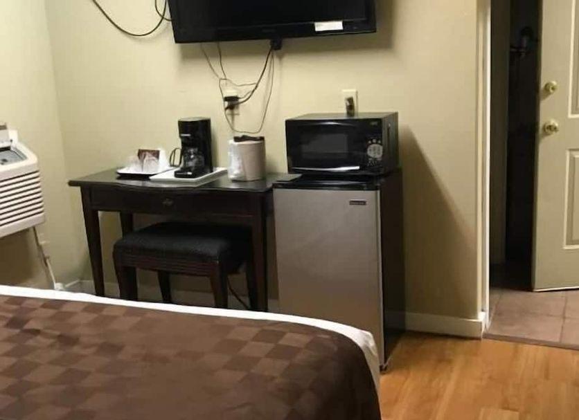 Desk with a flat-screen TV, coffee maker, microwave and refrigerator