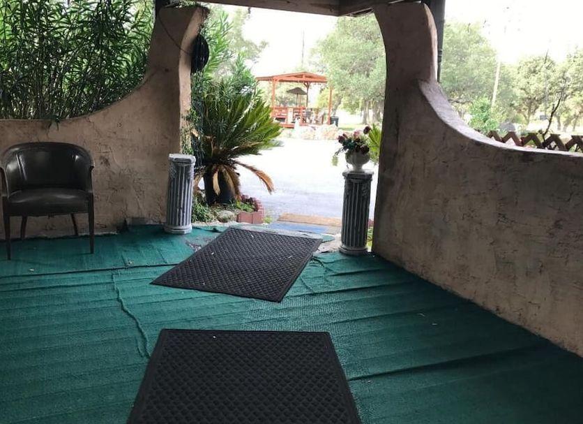 Shaded entry porch with a chair looking out to the pergola