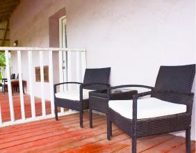 Two patio chairs and a side table on the shaded deck